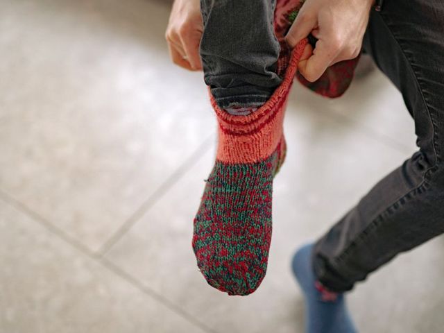 Eine Person zieht sich eine dicke Socke an
