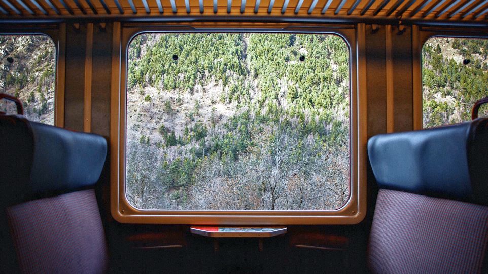 Blick durch ein Zugfenster in die Landschaft