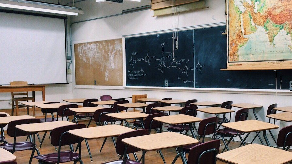 Leeres Klassenzimmer, an der Wand hängt eine große Weltkarte