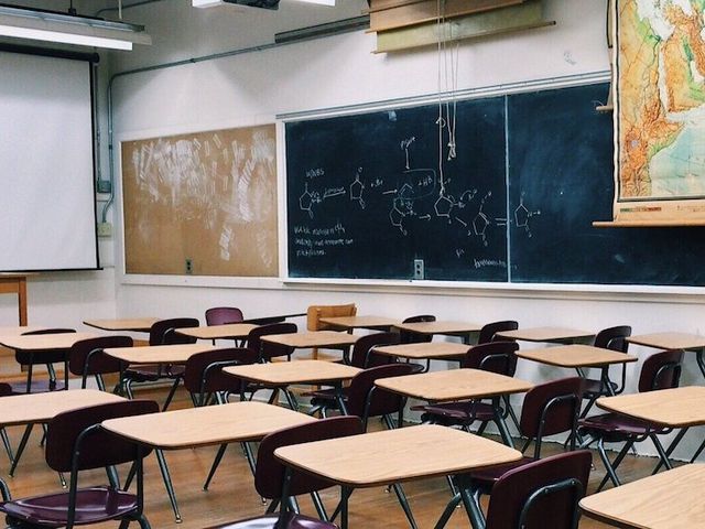 Leeres Klassenzimmer, an der Wand hängt eine große Weltkarte