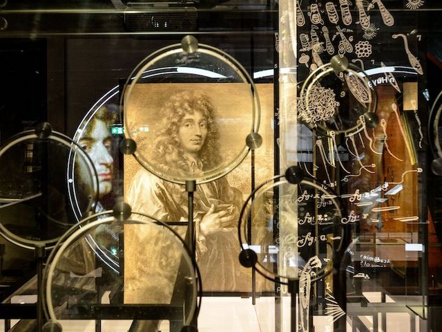 Eine Sammlung von Linsen von Christiaan Huygens mit seinem Porträt im Hintergrund