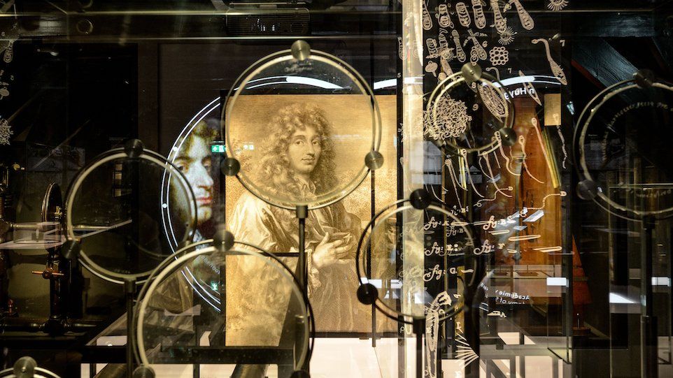 Eine Sammlung von Linsen von Christiaan Huygens mit seinem Porträt im Hintergrund