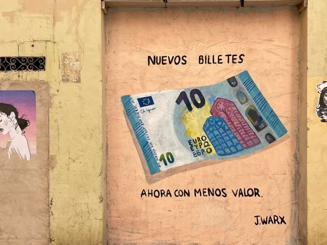 Gelbe Hauswand mit aufgemalten 10-Euro-Schein, dazu die Aufschrift: Nuevos billetes. Ahora con menos valor. 