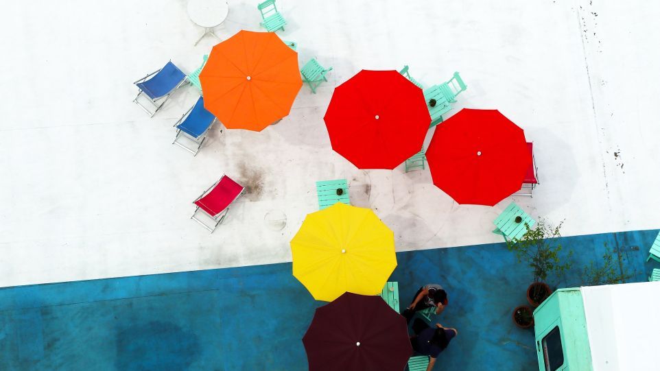 Bunte Sonnenschirme auf einer Dachterrasse, von oben gesehen