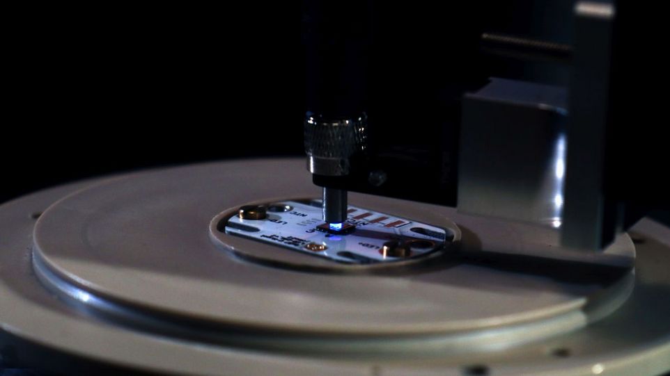 Runde Platte mit Chip, der von oben mit blauem Licht bestrahlt wird
