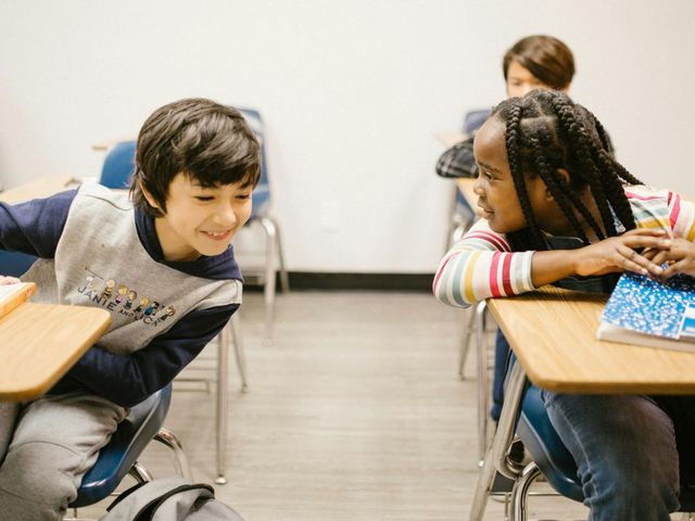 Eine Schülerin und ein Schüler sprechen im Klassenzimmer miteinander
