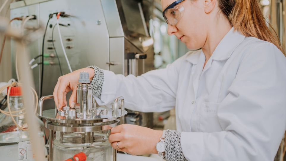Wissenschaftlerin an einem Bioreaktor