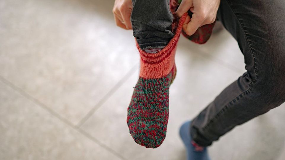 Eine Person zieht sich eine dicke Socke an