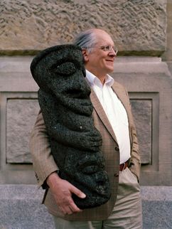 Manfred Krifka mit einer schwarzen Skulptur im Arm, deren Augen geschlossen und deren Hände vor dem Bauch verschränkt sind.