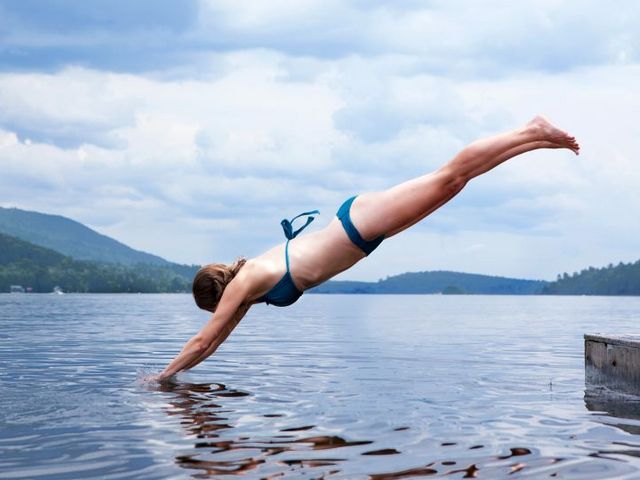 Junge Frau macht einen Kopfsprung in einen See