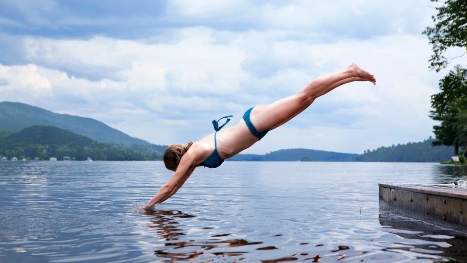 A girl jumps into the lake