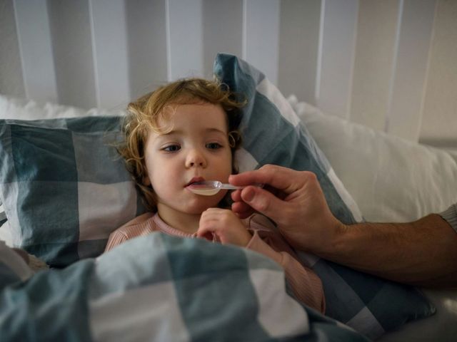 Kind erhält Medizin von einem Löffel