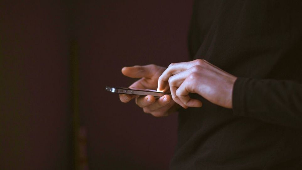 Hände halten ein Handy