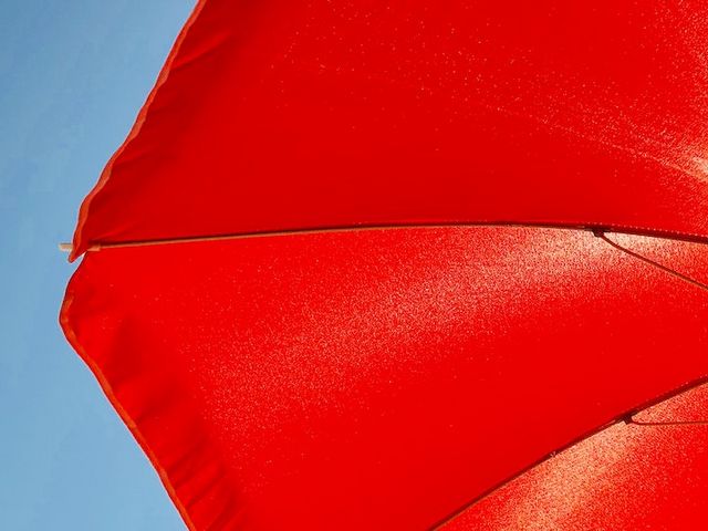 Red parasol in front of the sun