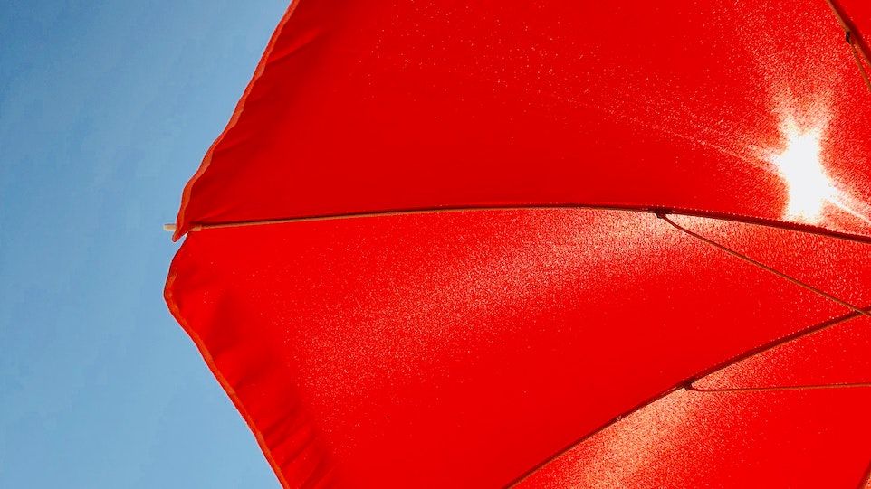 Red parasol in front of the sun