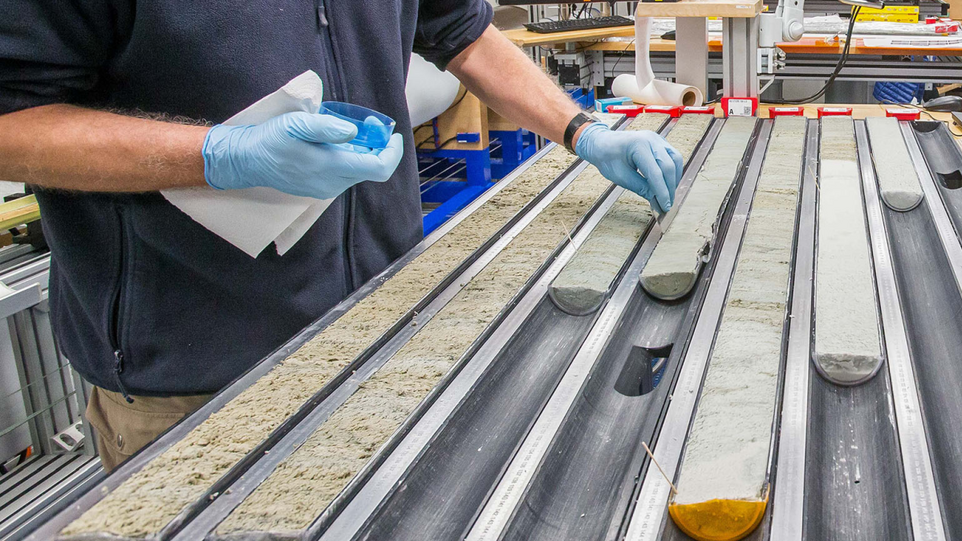 Blick in das Sedimentkern-Labor des Forschungsschiffs JOIDES Resolution, das 2019 auch den Kern im Südostpazifik gewonnen hat, der in der aktuellen Studie als Klimaarchiv ausgewertet wurde. Erdbohrkern in Röhren, Mann mit Petrischale in der Hand nimmt Proben