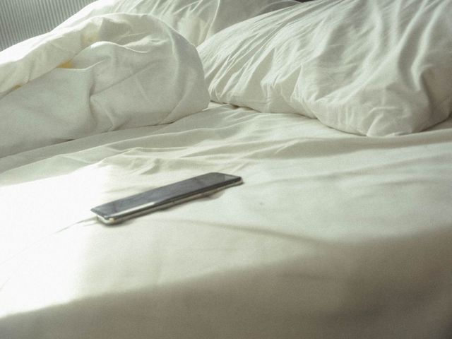 Smartphone in zerwühltem Bett