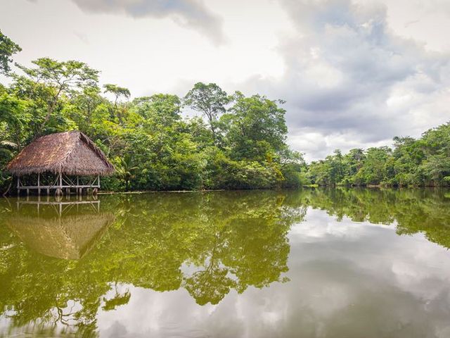 Amazonas mit spiegelnder Wasseroberfläche, im Hintergrund Steghaus