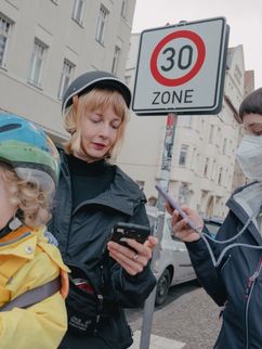 Die Troposphärenforscherin Liina Tõnisson ist mit ihrer kleinen Tochter und unserer Reporterin Amelie Berboth mit dem Fahrrad in Leipzig unterwegs. Sie lesen die Feinstaubbelastung über eine App auf dem Smartphone ab.