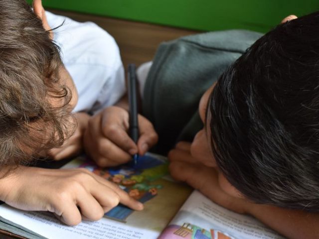 Two primary school pupils scribble in a school book