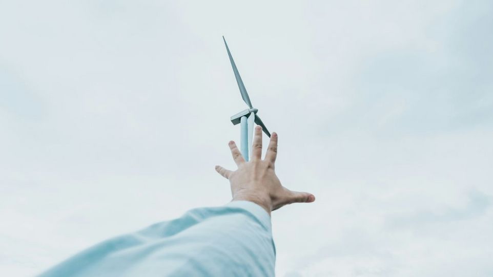 Hand reaches for wind turbine