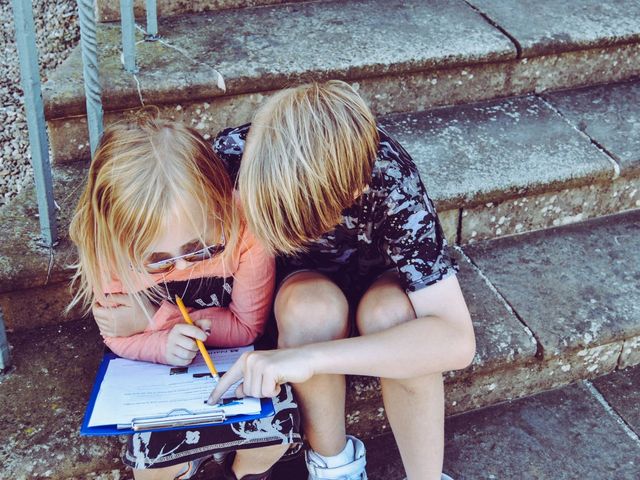 Zwei Kinder beugen sich über ein Aufgabenblatt