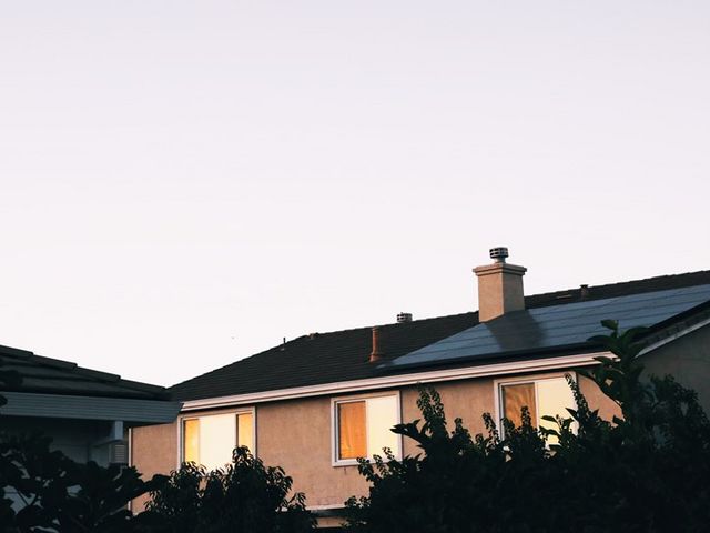Mehrfamilienhaus in Abendstimmung mit Solarzellen auf dem Dach