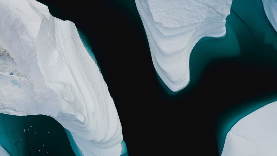 Eisberge von oben in dunklem Gewässer