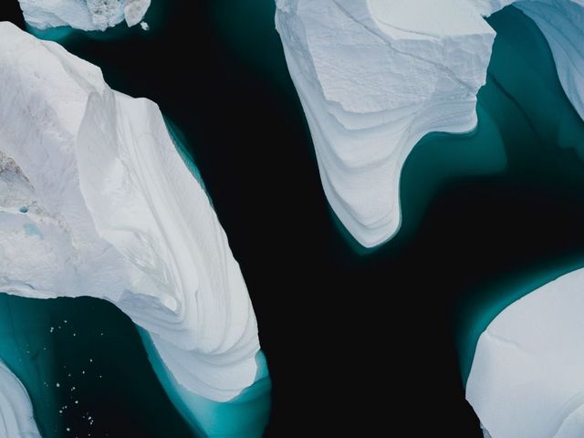 Eisberge von oben in dunklem Gewässer