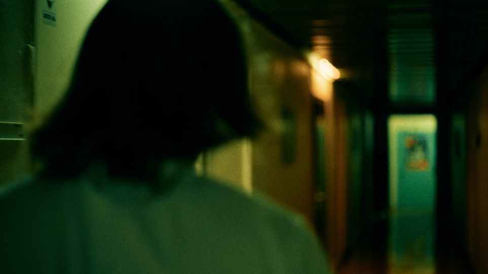 Woman from behind in a dark corridor