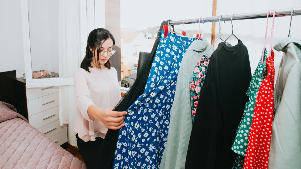 Young woman in front of a clothes rack