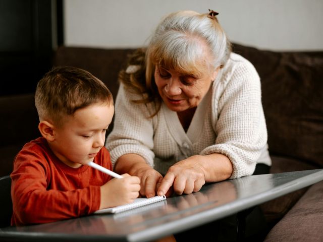 Ältere Frau unterstützt ein Kind beim Lernen