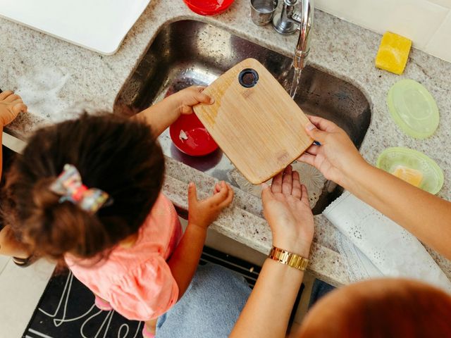 Zwei Kleinkinder lernen, ein Brettchen abzuspülen