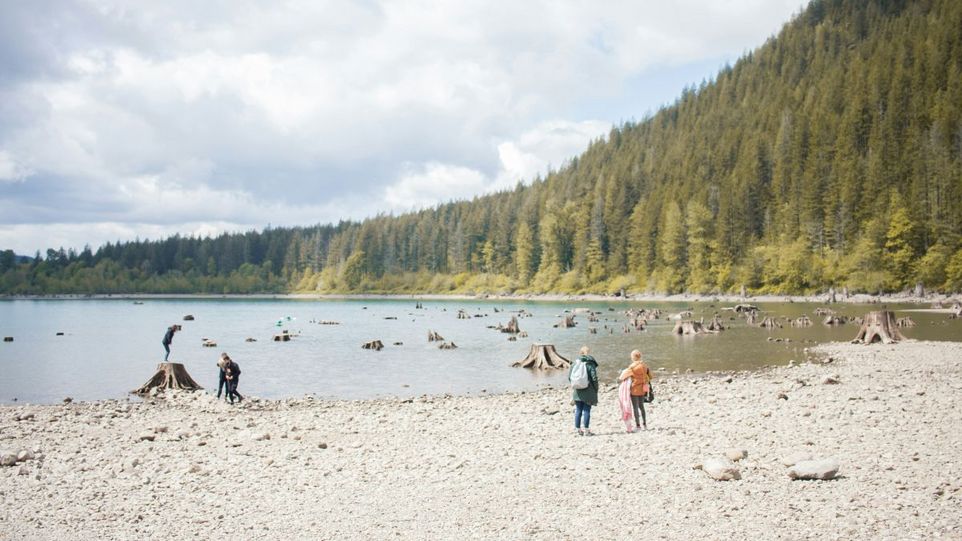 Halb ausgetrockneter See mit Menschen am Ufer