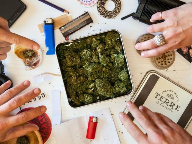 Blick von oben auf einen ungeordneten unter anderem mit Cannabisblüten und Feuerzeugen