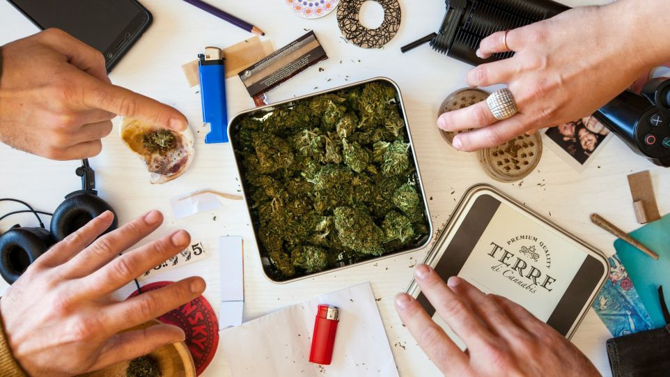 Blick von oben auf einen ungeordneten unter anderem mit Cannabisblüten und Feuerzeugen