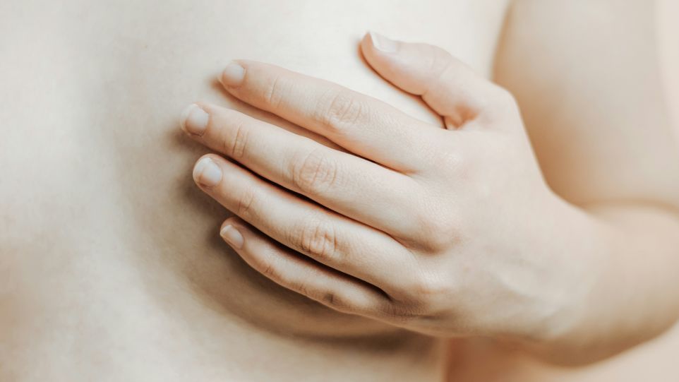 Eine Hand liegt flach auf einer Brust