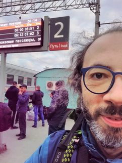 Gianluca Grimalda mit Rucksack in einer belebten Bahnhofshalle.
