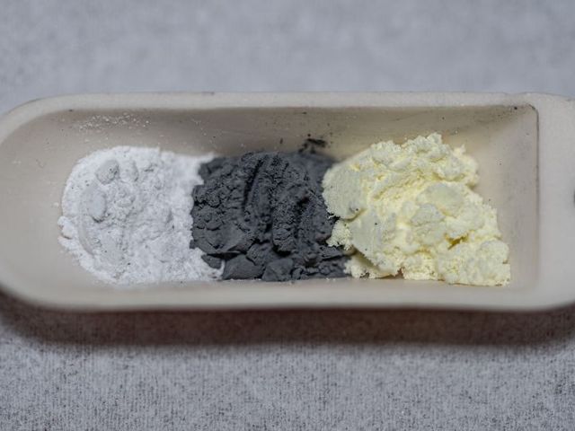 Kostengünstige und ungiftige Ausgangsstoffe nebeneinander geschichtet:  Lithiumoxid (weiß), Eisen (grau) und Schwefel (gelb) 
