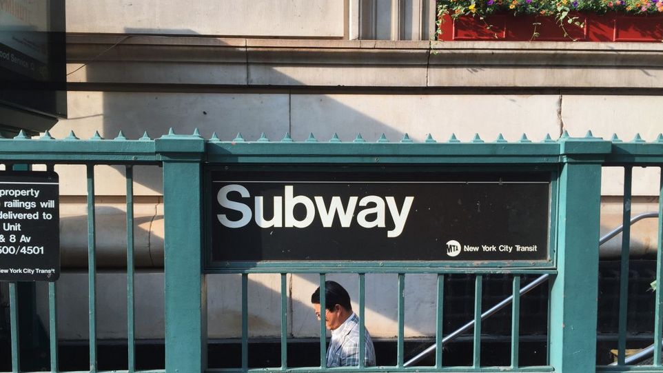 Mann geht Treppe zur Subway hinunter