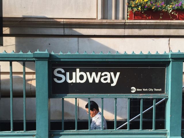 Mann geht Treppe zur Subway hinunter