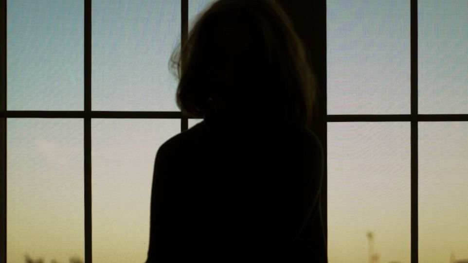 Frauensilhouette vor einem Fenster