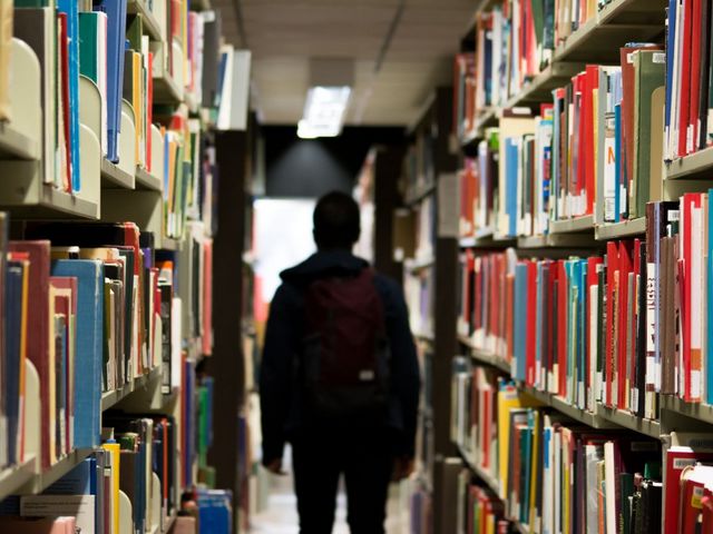 Silhouette eines Mannes in einer Unibibliothek