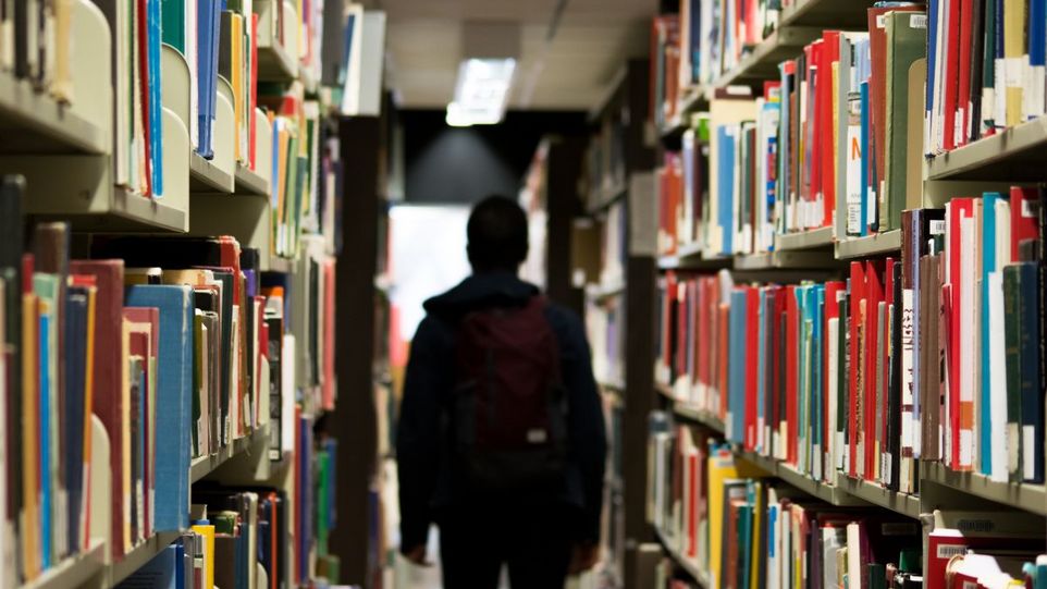 Silhouette eines Mannes in einer Unibibliothek