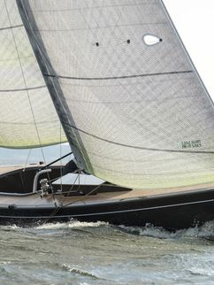 Segelboot bei leichtem Wellengang, es liegt leicht geneigt im Wasser.