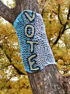 Strickschal an einem Baum mit Aufschrift "Vote"
