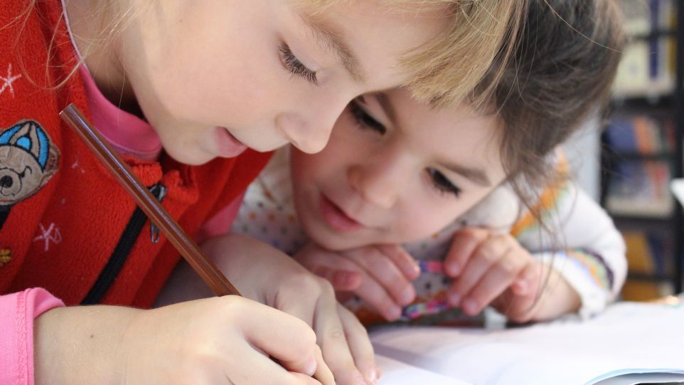 Geflüchtete ukrainische Kinder haben gute Chancen im deutschen Schulsystem Zwei Mädchen beugen sich über ein Schulheft