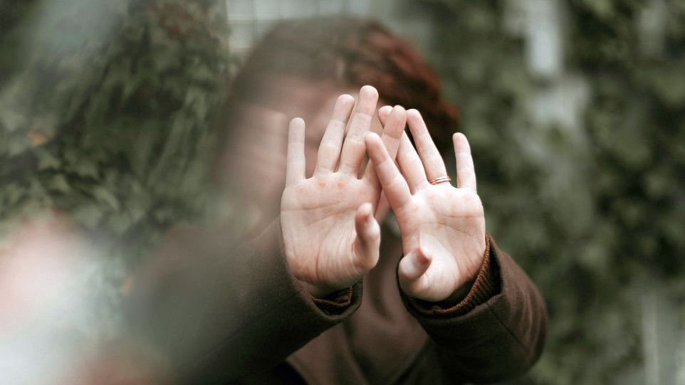 Frau, die die Hände abwehrend ausstreckt