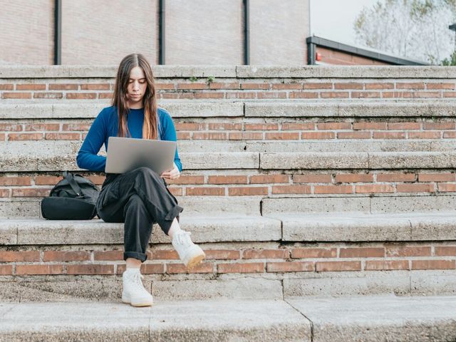 Junge Frau mit Laptop auf einer Treppe