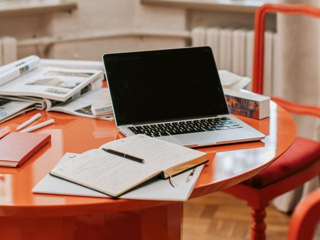 Tisch mit Laptop und Schreibutensilien